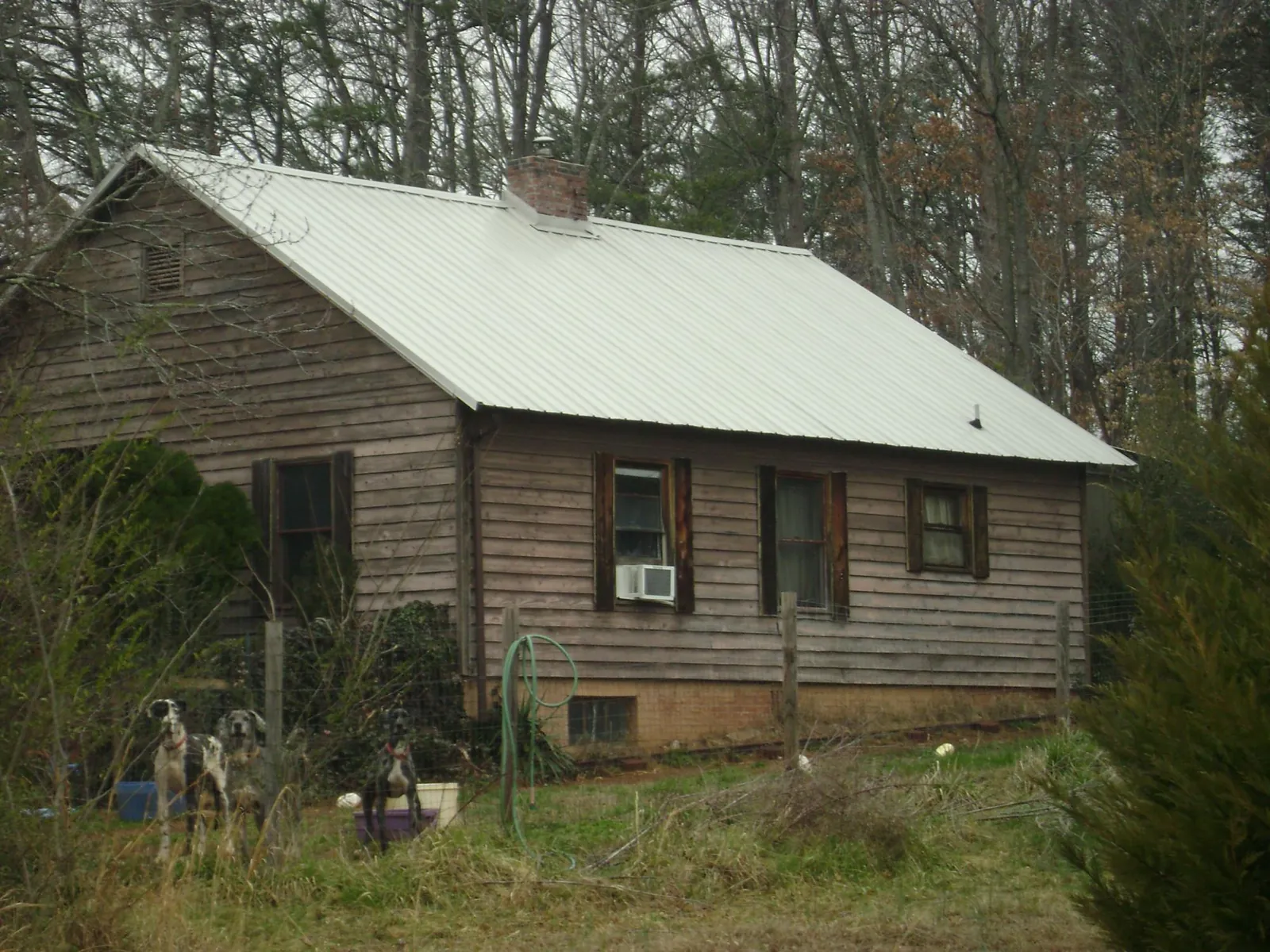 White metal roof on an old wood sided farmhouse, from a Metal Roof Installation job in Aylett